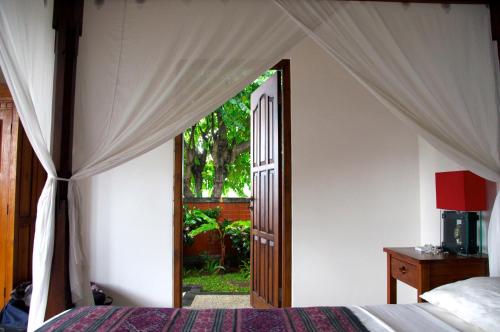 um quarto com uma cama e uma porta aberta em Villa Bali Pondok Jepang em Lovina