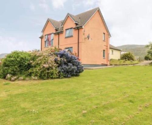 a large house in a field of green grass at Princes point villa all on ground floor in Portree