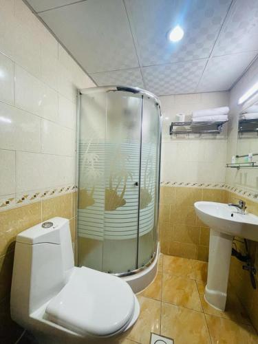 une salle de bain avec une douche, des toilettes et un lavabo dans l'établissement Crown Palace Hotel, à Ajman