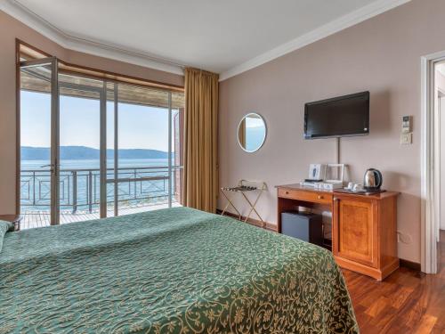 um quarto de hotel com uma cama e uma grande janela em Villa Cappellina em Toscolano Maderno