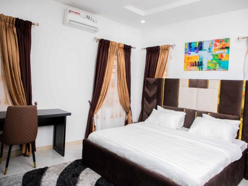 a bedroom with a bed and a desk and a table at Delight Apartments in Lagos