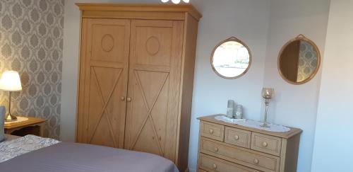 a bedroom with a wooden cabinet and a bed and a mirror at Haus Tina in Mölln