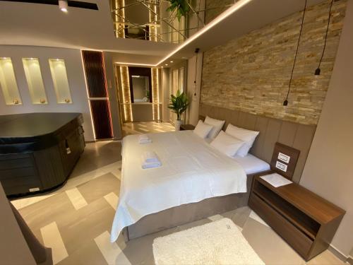 a bedroom with a large bed and a sink at Spa Pleasure Apartman in Novi Sad