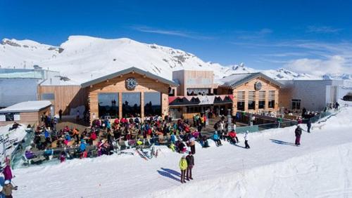 a crowd of people in front of a building in the snow at Apartment with Garden Daltons 1 in Crans-Montana