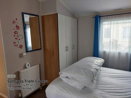 a bedroom with a bed and a mirror and a window at 205 Holiday Resort Unity Pet friendly pass includ in Brean