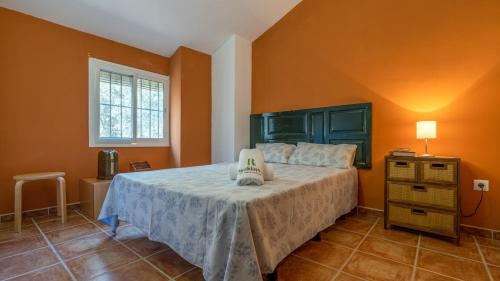 a bedroom with a large bed with orange walls at Casa Ginés Iznájar by Ruralidays in Iznájar