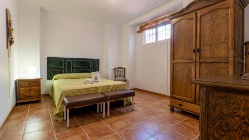 a bedroom with a bed and a table and a dresser at Casa Ginés Iznájar by Ruralidays in Iznájar