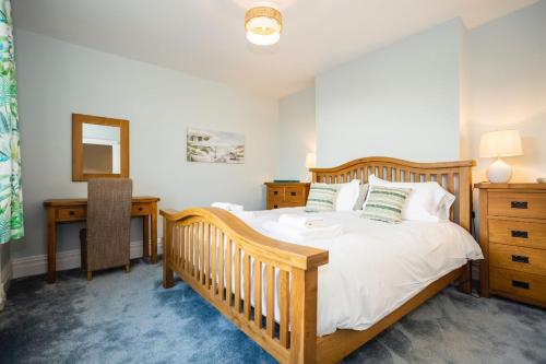 um quarto com uma cama de madeira e uma secretária em SAUNTON NORBORO 4 Bedrooms em Braunton