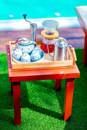 a table with a tray with dishes and a tea pot at Chateau de Luxi Khao Yai - ชาโตว์ เดอ ลูซี่ เขาใหญ่ in Mu Si