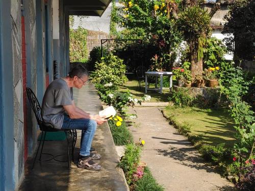 a man sitting on a bench in a garden at Hotel Mountain View - Lakeside Pokhara in Pokhara