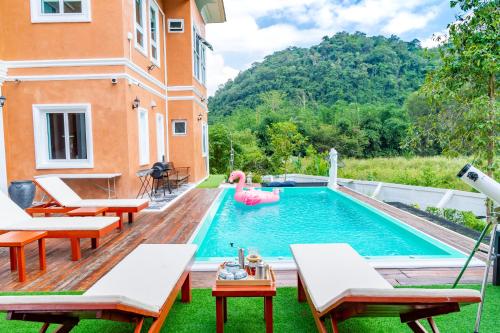a swimming pool with chairs and a pool noodle in a backyard at Chateau de Luxi Khao Yai - ชาโตว์ เดอ ลูซี่ เขาใหญ่ in Mu Si