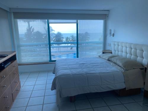 - une chambre avec un lit et une grande fenêtre dans l'établissement Bahia Dorada 3 habitaciones, à Pampatar