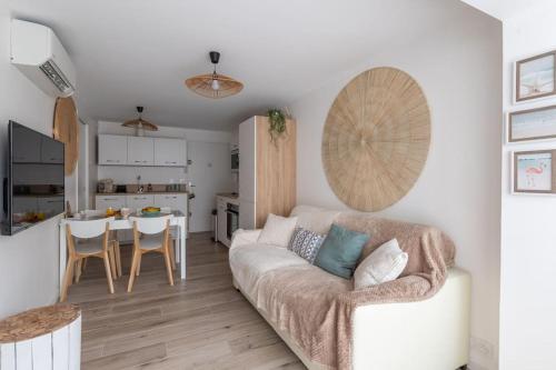 un salon avec un canapé et une cuisine dans l'établissement La Perle du Port * Terrasse * clim * mer à 5 min * chambre *, à Carnon-Plage