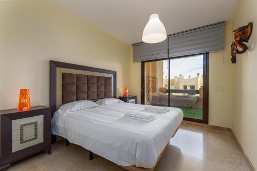 1 dormitorio con cama grande y ventana grande en 2199-Apt with terrace and pools, en Manilva