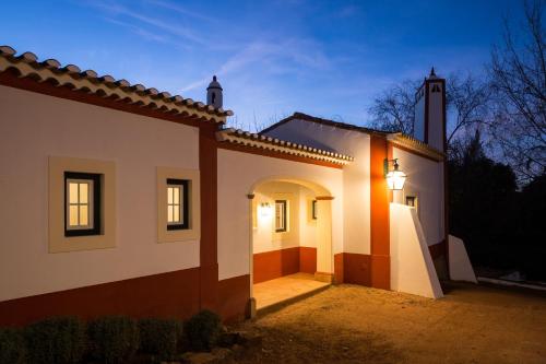 a house with a street light next to a church at Hotel Rural Monte da Provença in Elvas