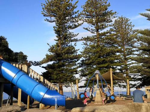 un groupe de personnes jouant sur une aire de jeux dans l'établissement Orewa Lovely Cozy Home, à Auckland