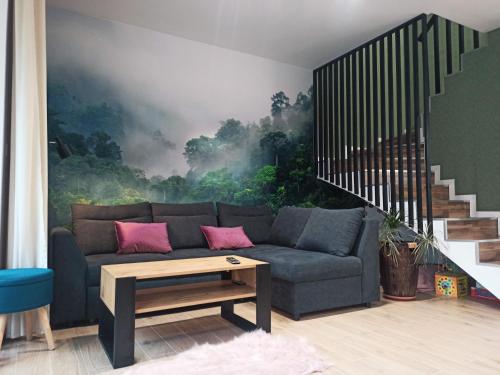 a living room with a couch in front of a mural at Dom nad jeziorem WIDOKówka in Żywiec