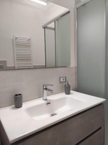 a bathroom with a white sink and a mirror at Apartment NAPOLI MARADONA in Naples