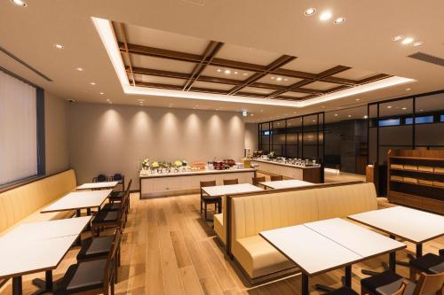 a fast food restaurant with tables and a counter at Sotetsu Grand Fresa Kumamoto in Kumamoto