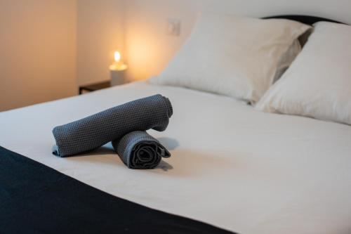 un rouleau de fil noir assis sur un lit blanc dans l'établissement Atlantic Selection - Proche du golf - Au calme avec parking, à Capbreton