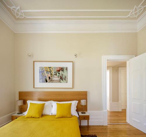 a bedroom with a yellow bed with two yellow pillows at Casa Kala in Porto