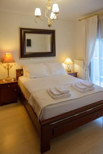 a bedroom with a bed with two lamps and a mirror at Luxury Dafnis House in Veria