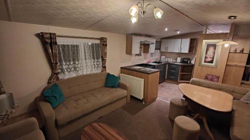 a living room with a couch and a table and a kitchen at BUTLINS SKEGNESS, 3 Beds, Pet Friendly - The Paddock in Lincolnshire
