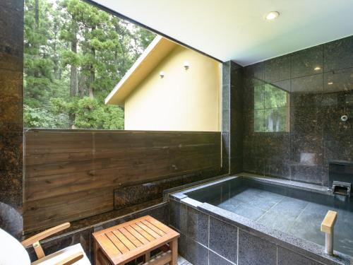 a bath tub in a room with a window at Hakone Suishoen in Hakone