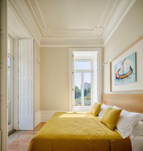 a bedroom with a large bed with a window at Casa Kala in Porto