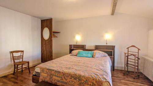 sypialnia z łóżkiem i 2 krzesłami w obiekcie Gîte de la Harpe au 4bis w mieście Vauvillers