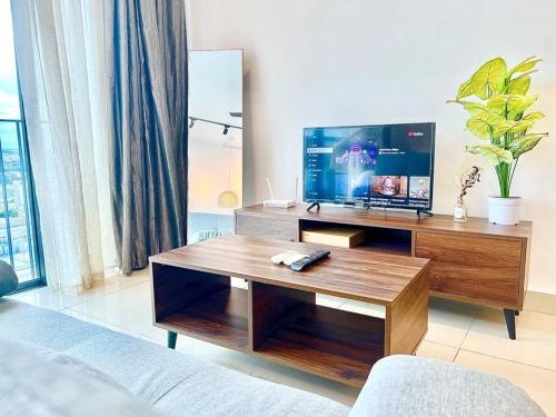 a living room with a tv and a coffee table at G 1-5pax Cozy Home Trefoil Setia Alam 100mps Wifi & TV SCCC in Setia Alam