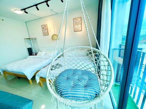 a white swing in a room with a bed at G 1-5pax Cozy Home Trefoil Setia Alam 100mps Wifi & TV SCCC in Setia Alam