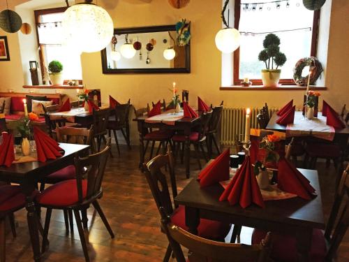 a restaurant with tables and chairs with red napkins at Hotel Landgasthof Sonne in Mahlberg