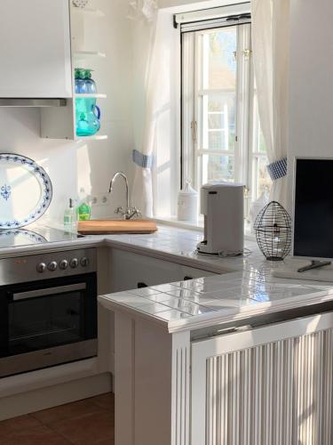 a kitchen with white cabinets and a counter top at Villa Deichhof in Dunsum