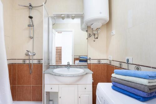 y baño con lavabo, espejo y toallas. en Villa Palm Mar en El Palmar