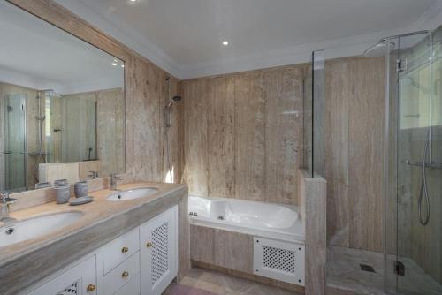 a bathroom with two sinks and a tub and a shower at Spacious ground floor apartment in Casares Costa in Casares
