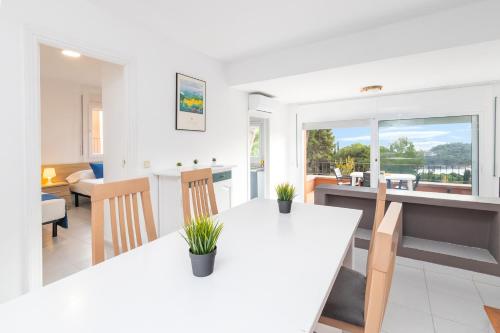 a kitchen and living room with a white table and chairs at Apartaments Aiguablava in Begur