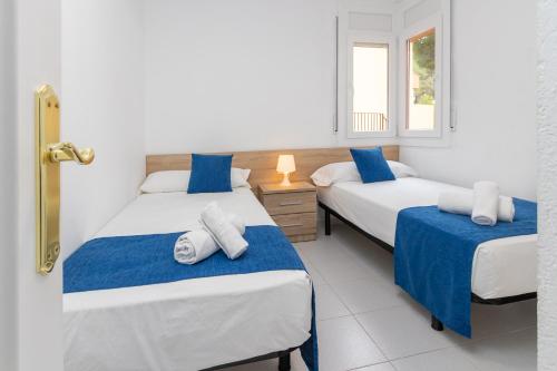 um quarto com 2 camas e uma janela em Apartaments Aiguablava em Begur