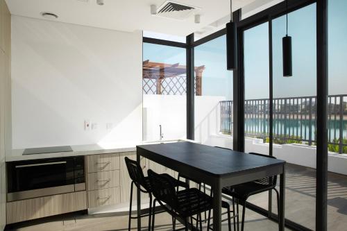 a kitchen with a black table and chairs on a balcony at Beach Villas by Olala Homes in Ras al Khaimah