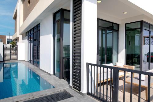 a house with a swimming pool and a balcony at Beach Villas by Olala Homes in Ras al Khaimah