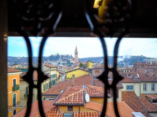 een uitzicht vanuit een raam van een stad met daken bij ApartmentsArena - Residenza Degli Scaligeri - Piazza Erbe in Verona