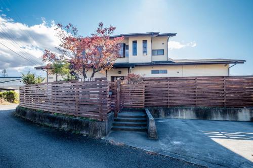 a fence in front of a house with a house at Engawa House Momiji-With hot spring in Fujikawaguchiko