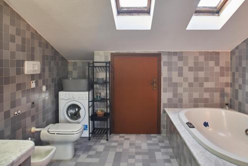ein Badezimmer mit einem WC, einer Badewanne und einer Waschmaschine in der Unterkunft Little Brick House on Siena Hills with Balconies in Siena