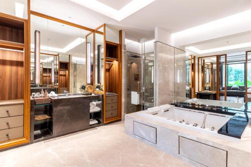 Villa Deva Resort & Hotel Bangkok في بانكوك: حمام مع حوض استحمام كبير ودش