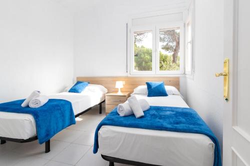 two beds in a room with a window at Apartaments Aiguablava in Begur