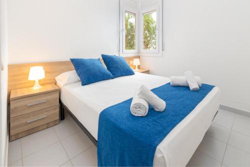 a bedroom with two beds with blue and white sheets at Apartaments Aiguablava in Begur