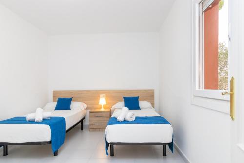 a bedroom with two beds and a window at Apartaments Aiguablava in Begur