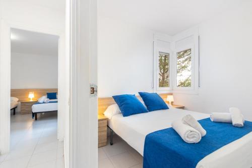 a bedroom with two beds with blue pillows at Apartaments Aiguablava in Begur