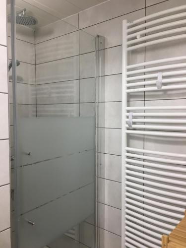een badkamer met een douche en witte betegelde muren bij Mont Vallon Lodge- Méribel Mottaret, Skis aux pieds, proche du centre et tout confort, Parking gratuit et Linge fourni in Méribel