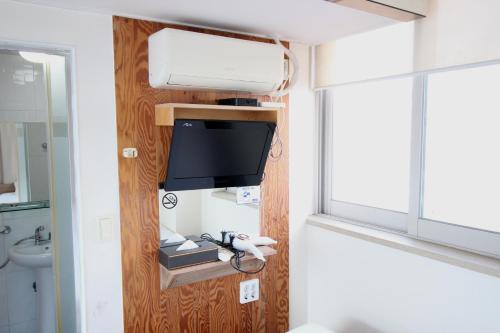 La salle de bains est pourvue d'une télévision, d'un lavabo et d'un miroir. dans l'établissement Hostel Kpop, à Séoul